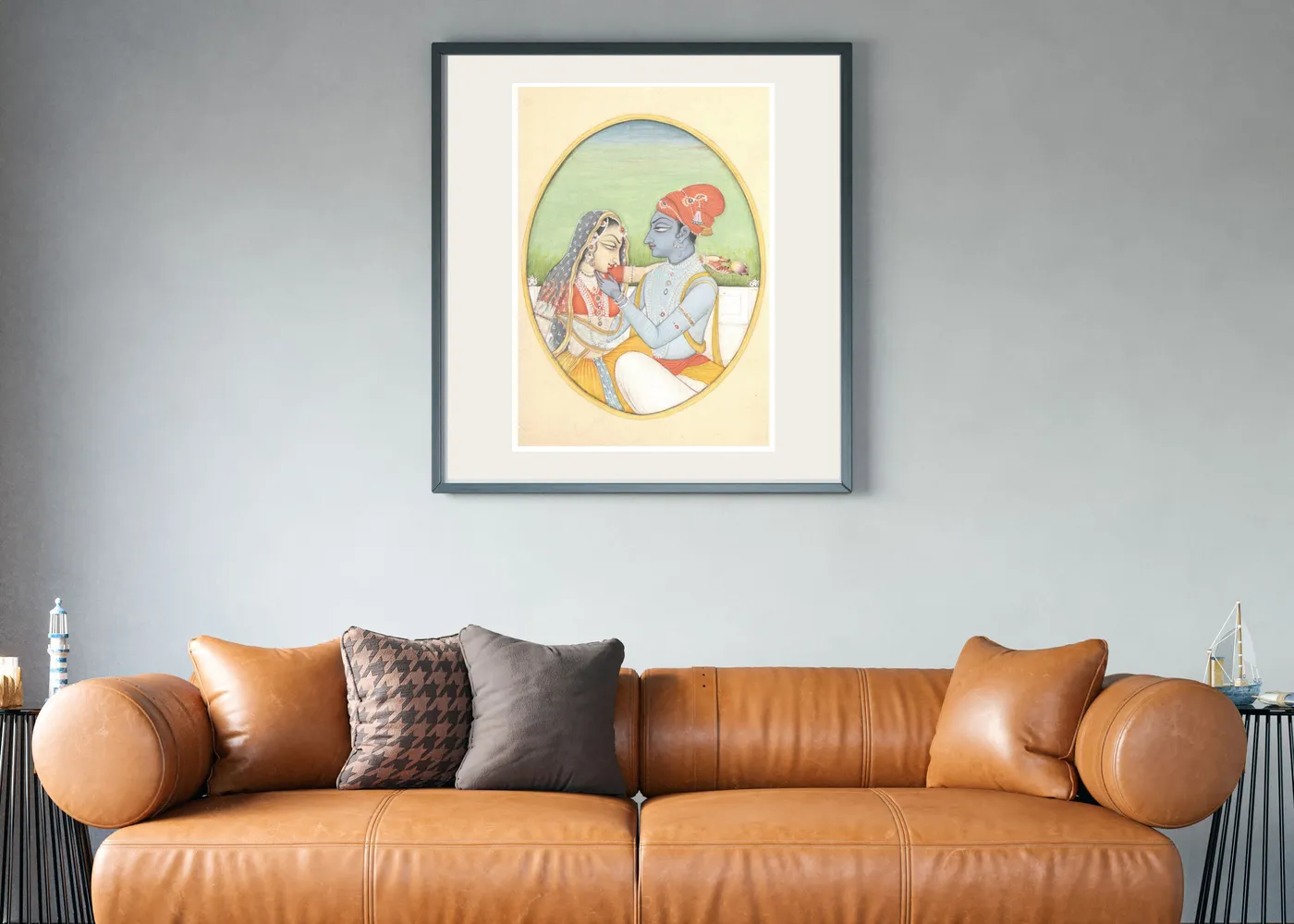 Radha Krishna miniature painting in a black frame on a white wall with plants